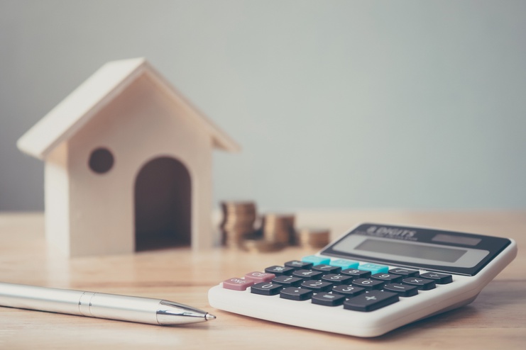 house miniature with calculator, ballpen, and coins